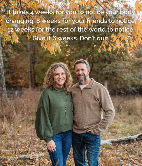 Photo of a smiling couple standing in a rustic autumn scene after losing weight following the Eat to Lose program